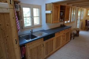 a kitchen with wooden cabinets and a sink at Wollhaus Oberzwirgi in Rohrmatten