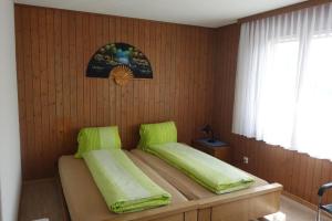 a bedroom with a bed with green cushions on it at Ferienwohnung Kathriner Durrer in Sarnen