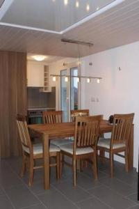 a dining room with a wooden table and chairs at Adlerhorst in Rosswald