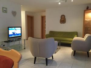 un soggiorno con divano, sedie e TV di Haus Mondelli a Saas-Almagell