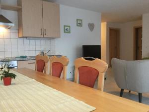 una cucina con tre sedie e un tavolo e un tavolo di Haus Mondelli a Saas-Almagell