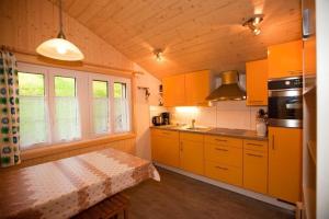 a kitchen with yellow cabinets and a table in it at 45 Zimmer Ferienwohnung Hofstatthaus in Hasliberg