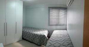 a bedroom with a bed and a window at Apartamento na Ponta Verde in Maceió