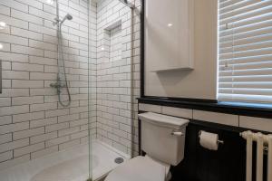 een badkamer met toilet en glazen douche bij Gorleston Beach House by Leap Escapes in Gorleston-on-Sea +11 foto's