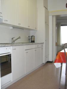a kitchen with white cabinets and a sink at Casa Reduit Terrazza in Orselina
