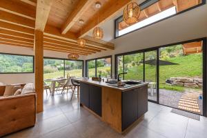 eine Küche mit einer Insel in einem Haus mit Fenstern in der Unterkunft Villa Alésia - Jacuzzi et vue montagnes, environnement apaisant in Saint-Eustache