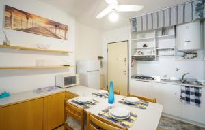 a kitchen with a table with chairs and a microwave at 2 Bedroom Lovely Apartment In Lavagna in Lavagna