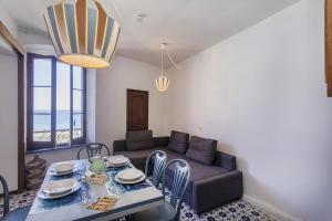a living room with a couch and a table and chairs at La Casa di Nonno Sallù by Wonderful Italy in Camogli