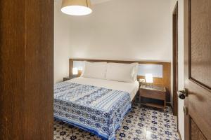 a bedroom with a bed with a blue and white blanket at La Casa di Nonno Sallù by Wonderful Italy in Camogli