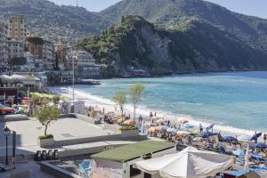 a beach with umbrellas and people on the beach at La Casa di Nonno Sallù by Wonderful Italy in Camogli
