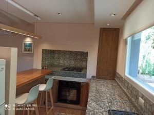 a kitchen with a stove and a counter with chairs at Duplex Luna in Pinamar