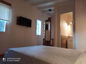 a bedroom with a bed and a flat screen tv at Duplex Luna in Pinamar