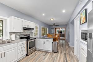 a kitchen with white cabinets and wooden floors at 2 Lakefront Cottages with Docks, Bikes, BBQ in Newaygo