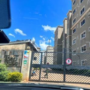 een hek voor enkele hoge gebouwen bij Kings Square Tebiz Haven in Eldoret