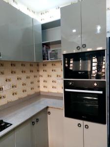 a kitchen with white cabinets and a black oven at 3 bedroom Apartment lekki Victory Homes in Mama