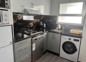 a kitchen with a stove and a washing machine at Almina plage in Fnidek
