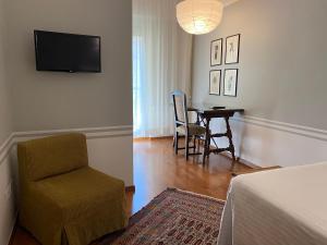 a bedroom with a table and a chair and a television at Hotel Lancelot in Rome