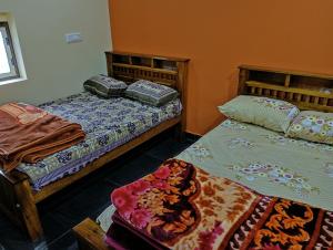 ein Schlafzimmer mit zwei Betten und einem Tisch in der Unterkunft TungaTeera Homestay in Sringeri