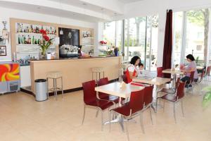 um restaurante com duas mulheres e uma criança sentada às mesas em EuroHotel em Cesenatico