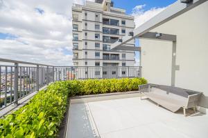 un balcón con un banco y un edificio en Flat c Piscina e Academia na Chacara Klabin, en São Paulo