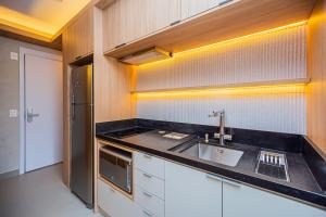 una cocina con fregadero y refrigerador en Flat c Piscina e Academia na Chacara Klabin, en São Paulo