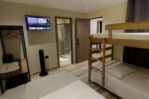 Una habitación con dos literas y un televisor. en Casa Indigo completa, en Medellín