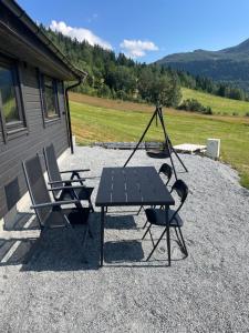 una mesa de picnic y dos sillas frente a una casa en Flott hytte i Sogndal skisenter-Hodlekve, en Sogndal 3 fotos más