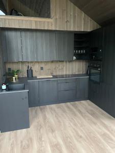 cocina con armarios grises y suelo de madera en Flott hytte i Sogndal skisenter-Hodlekve, en Sogndal