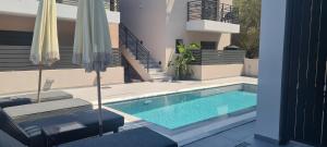 una piscina in una casa con un divano e una sedia di Theros a Nikiana