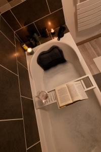 a bath tub with a book in it in a bathroom at La maison du jeu cnpe hypercentre plage 8pers jeux video et de société in Gravelines +37 photos