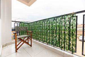 a chair on a balcony with a green wall at Lorien Homes in Nairobi