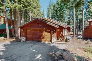 a large wooden building with a garage in the woods at The Tahoe House in Truckee