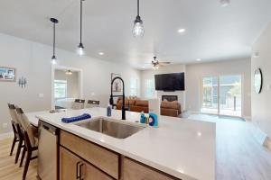 a kitchen with a sink and a living room at The Crossing at Lake Forest- 35 in Eagle River