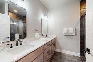 a bathroom with a sink and a large mirror at The Crossing at Lake Forest- 35 in Eagle River +18 photos