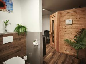 a bathroom with a toilet and a wooden wall at Gemütliche Souterrainwohnung in Immenhausen