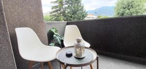 twee witte stoelen en een tafel op een balkon bij "LAGO VERDE" Como garage privato in Como