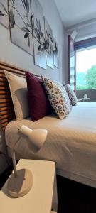 een slaapkamer met een bed met kussens en een raam bij "LAGO VERDE" Como garage privato in Como