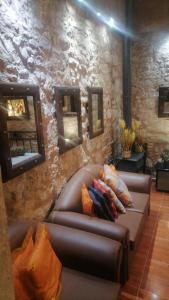a living room with a leather couch with pillows on it at Tryfonapartment school1922 in Krousón