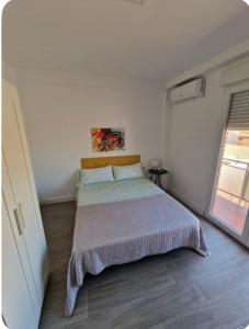 a white bedroom with a bed and a window at Habitacion BNB con balcon Alfarooms in Albacete