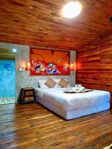 a bedroom with a large bed in a room with wooden walls at Wooden House Koh Lanta in Ko Lanta Yai
