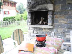 ein Tisch mit einem Topf auf einem Steinkamin in der Unterkunft Bright Chalet with Terrace in Randogne