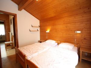 a bedroom with a large bed with a wooden wall at Bright Chalet with Terrace in Randogne +29 photos