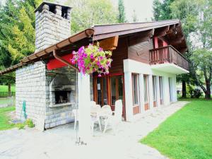 ein Haus mit Kamin und einem Balkon mit Blumen in der Unterkunft Bright Chalet with Terrace in Randogne