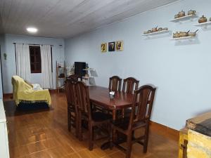 Un comedor con mesa y sillas de madera. en AlojamientolaFamilia, en Puerto Iguazú