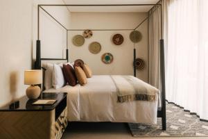 a bedroom with a bed and a table and a window at Our Habitas Ras Abrouq in Dukhān