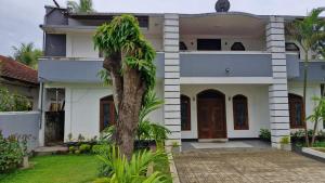 a house with a palm tree in front of it at Kamala villa in Jaffna
