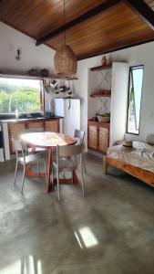 une cuisine et une salle à manger avec une table et des chaises dans l'établissement Casa Aratu Guaiú Barra de Mamanguape, à Rio Tinto