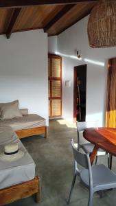 une chambre avec un lit, une table et des chaises dans l'établissement Casa Aratu Guaiú Barra de Mamanguape, à Rio Tinto