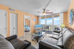 a living room with a couch and a ceiling fan at Oceania Plaza 808 in New Smyrna Beach