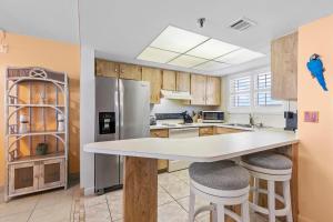 a kitchen with a large island with stools at Oceania Plaza 808 in New Smyrna Beach